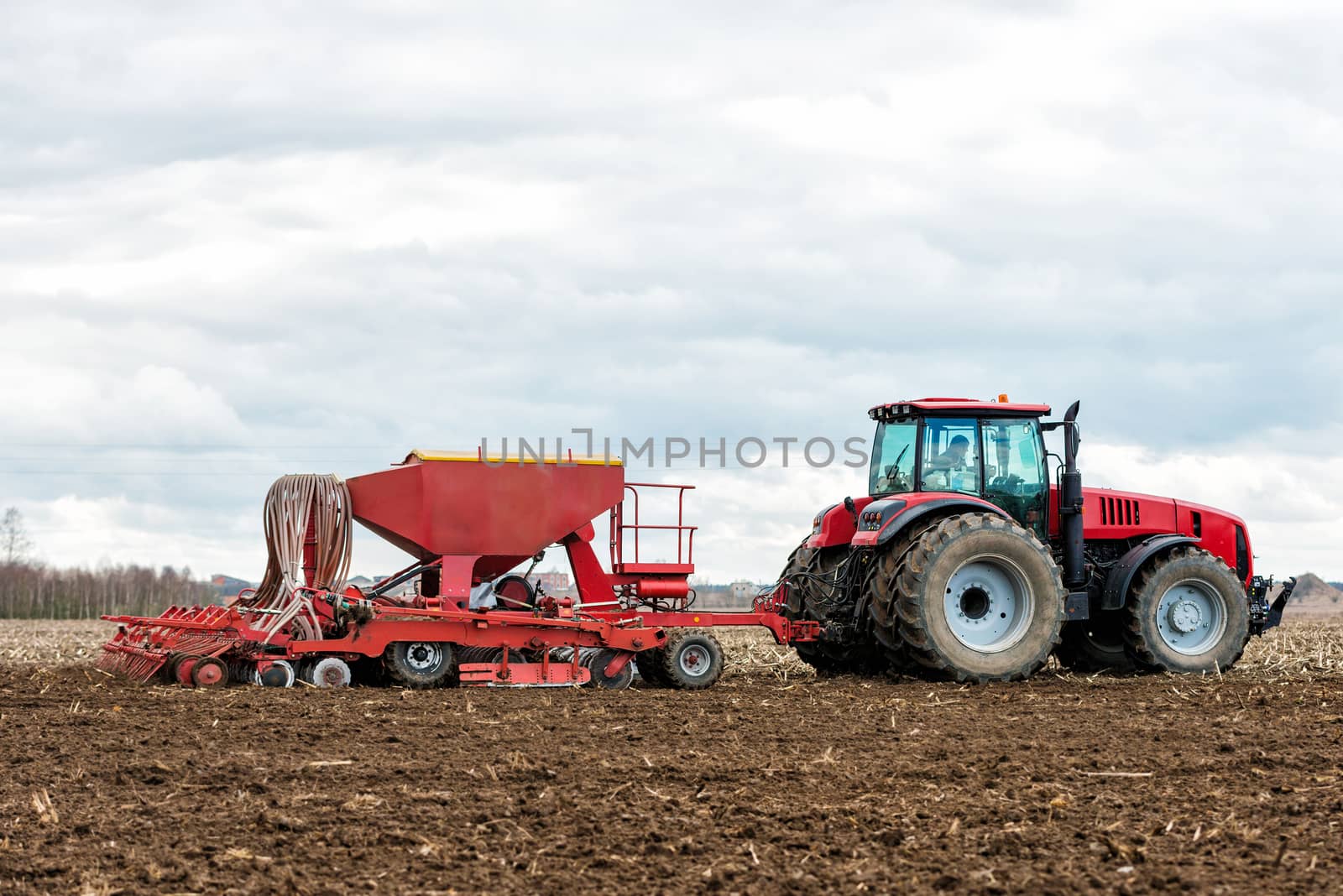 Farmer tractor working in the field. Spring time for sowing. Planting crops. 