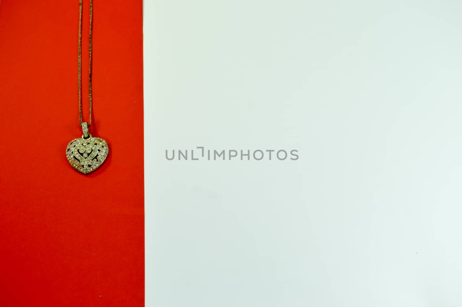 Heart-shaped pendant on a red strip on a white background