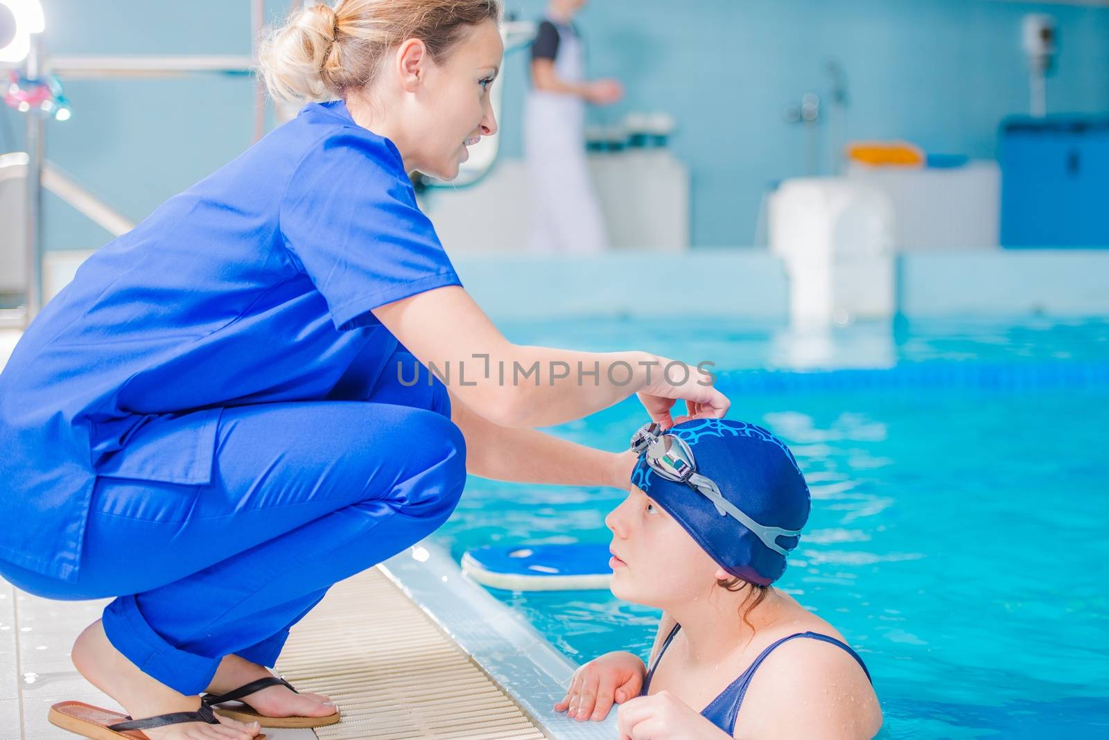Rehabilitation in Swimming Pool. Medical Staff Supervising Children Rehabilitation in the Rehabilitation Center Pool.