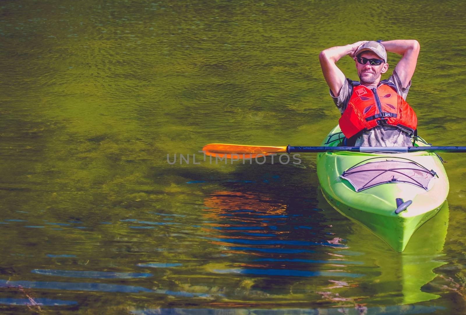 Relaxed Kayaker on the Lake. Caucasian Sportsman. Water Sports and Recreation Concept.