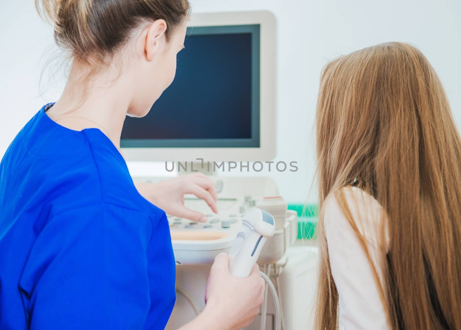 Female Doctor Preparing Little Caucasian Girl For Ultrasonography Imaging. Ultrasonography For Children