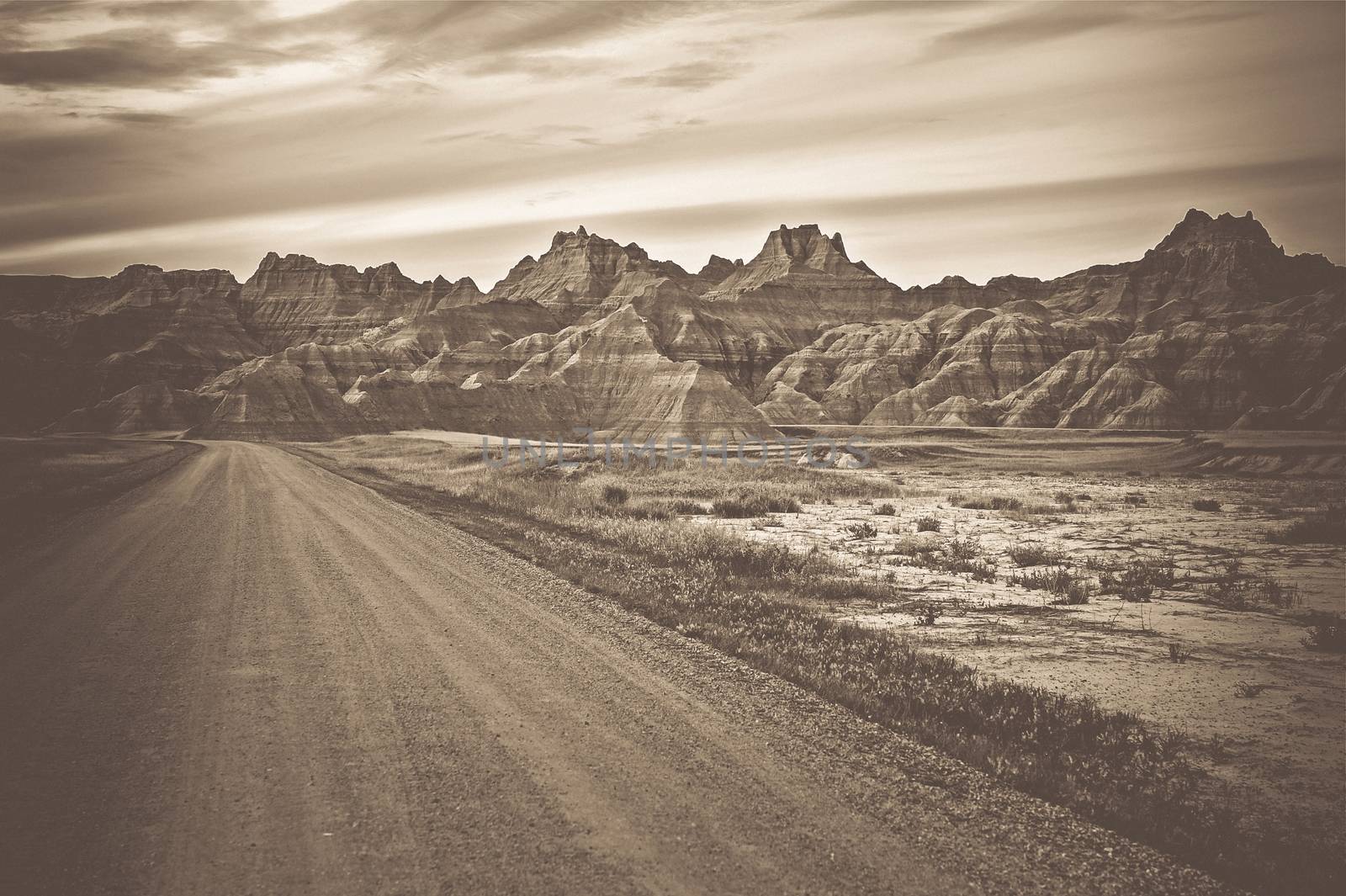 Raw Badlands Landscape in Sepia Color Grading. South Dakota Nature Landscape and the Rural Road.