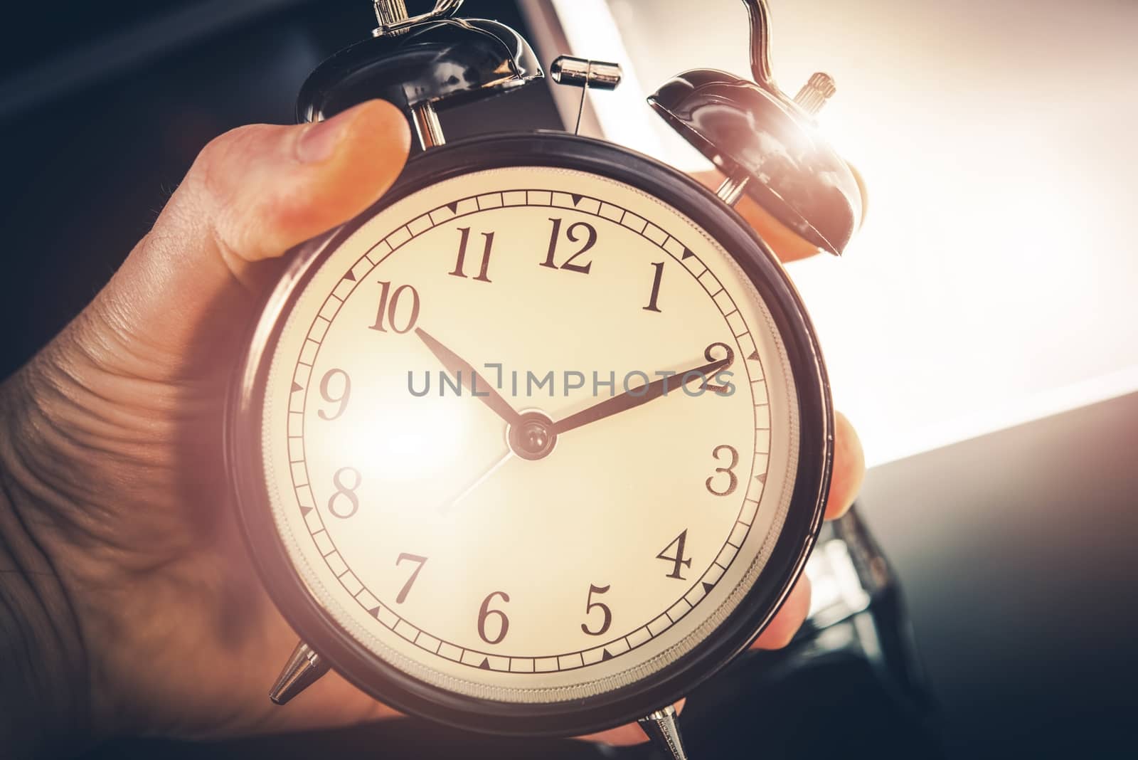 Time is Running Out. Large Classic Alarm Clock in a Hand.