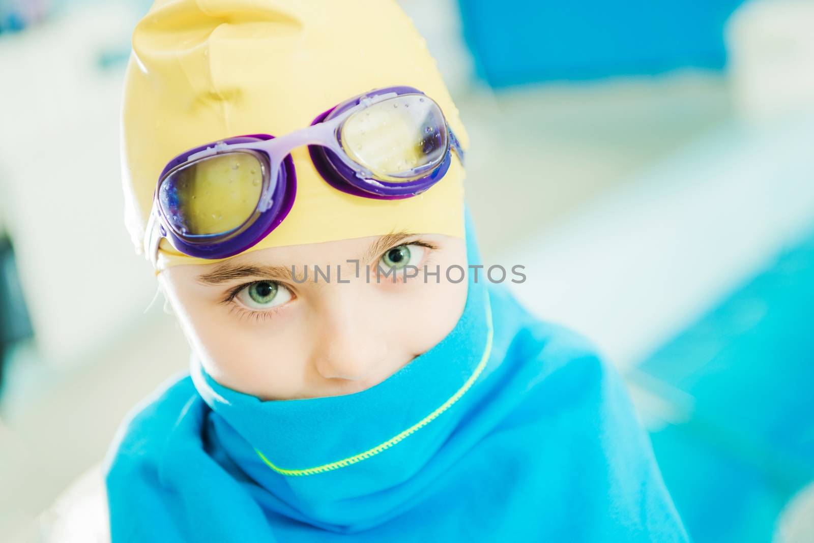 Swimming Pool Fun Time. Caucasian Girl Covered By Pool Blue Towel. Closeup Photo. Girl Wearing Water Goggles