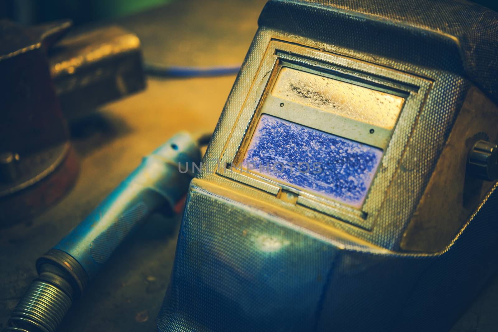 Welding Mask and the Welder Gun Closeup Photo.