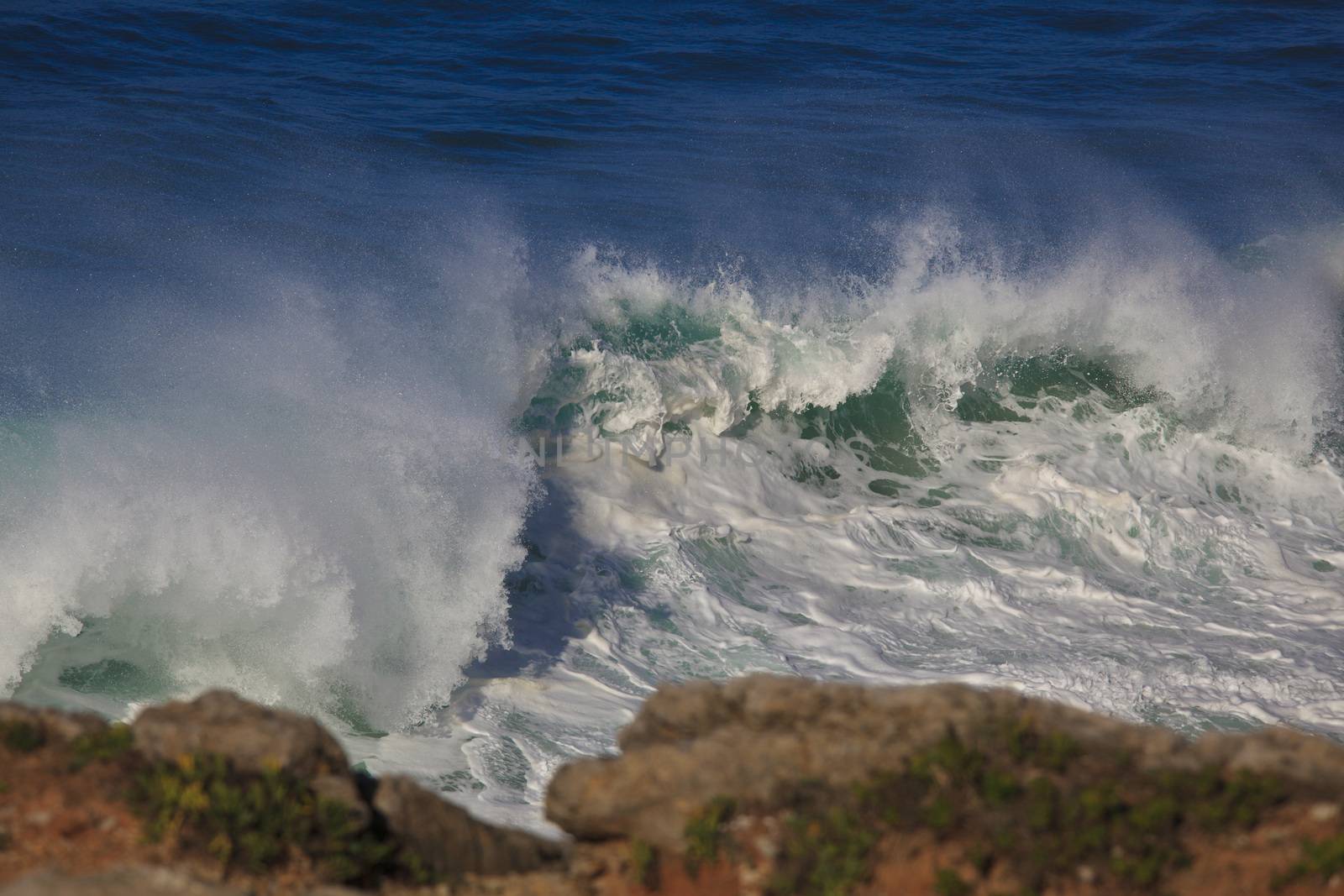 Marine wave breaks against offshore stone