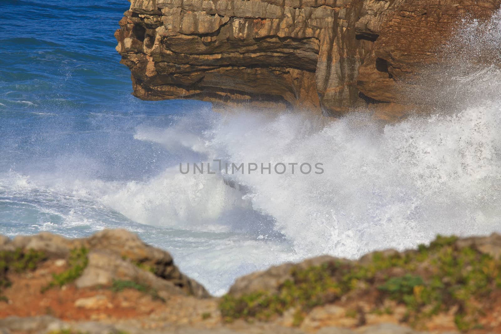 Marine wave breaks against offshore stone