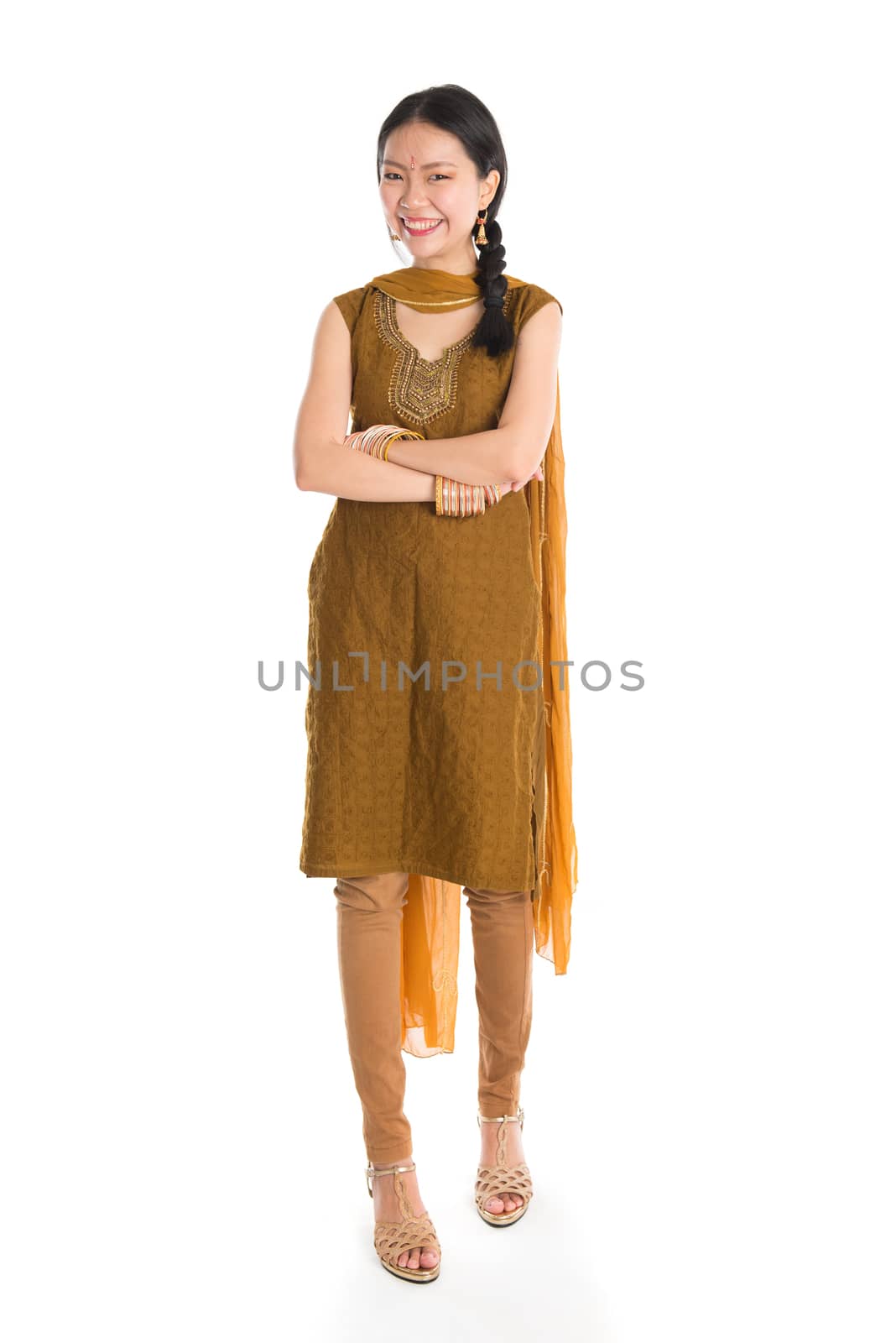 Portrait of young mixed race Indian Chinese girl in traditional punjabi dress smiling and looking at camera, full length standing isolated on white background.