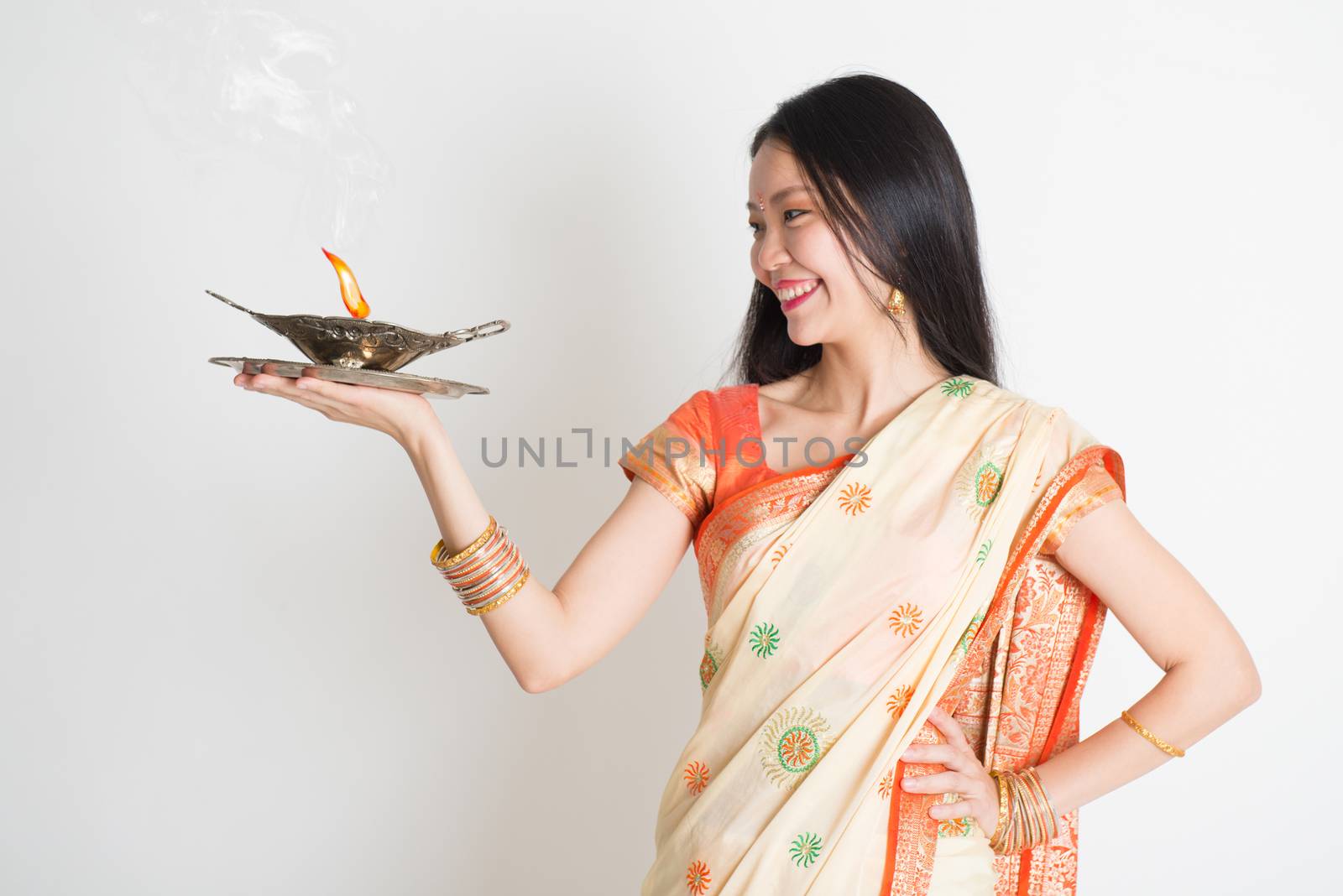 Girl with Indian sari dress holding oil lamp by szefei