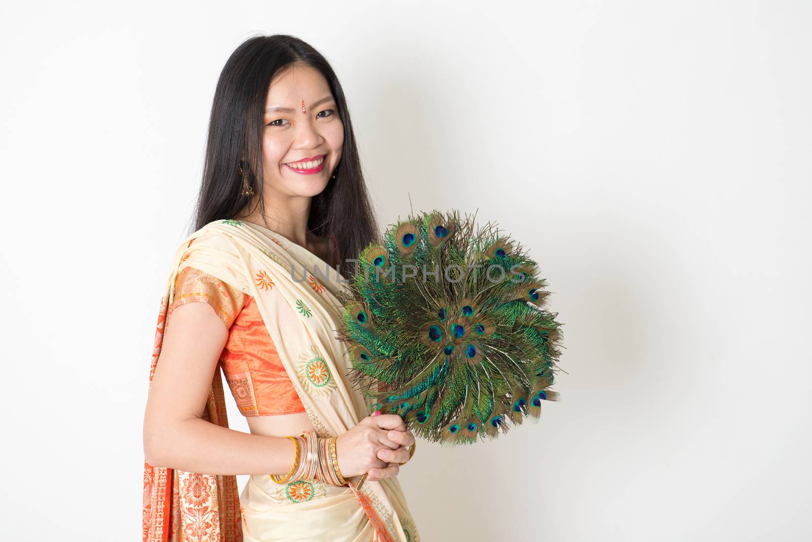 Young woman with peacock feather fan in Indian sari dress by szefei