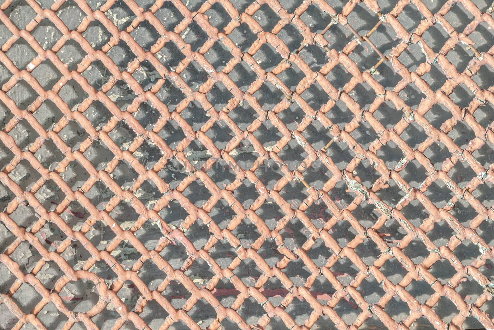fragment of an old metal grid is covered with paint, which has long been under the influence of different climatic conditions