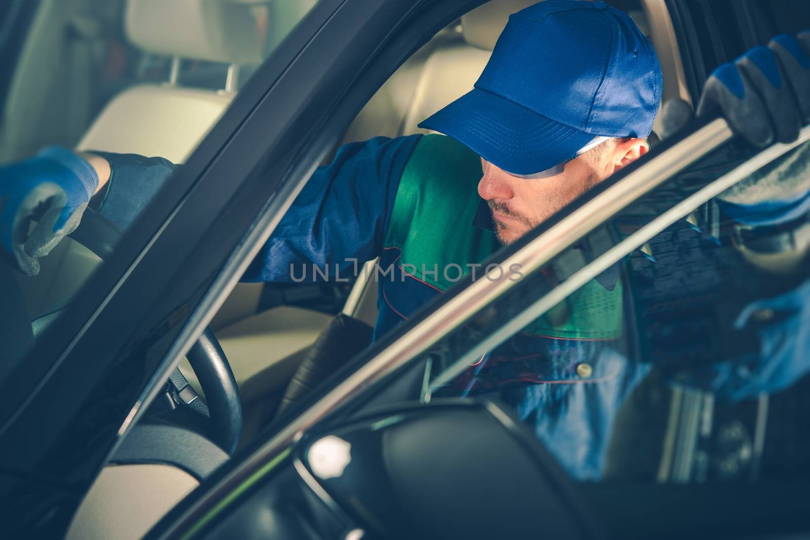 Car Mechanic Fixing Vehicle While Seating Inside the Car. Professional Car Maintenance.
