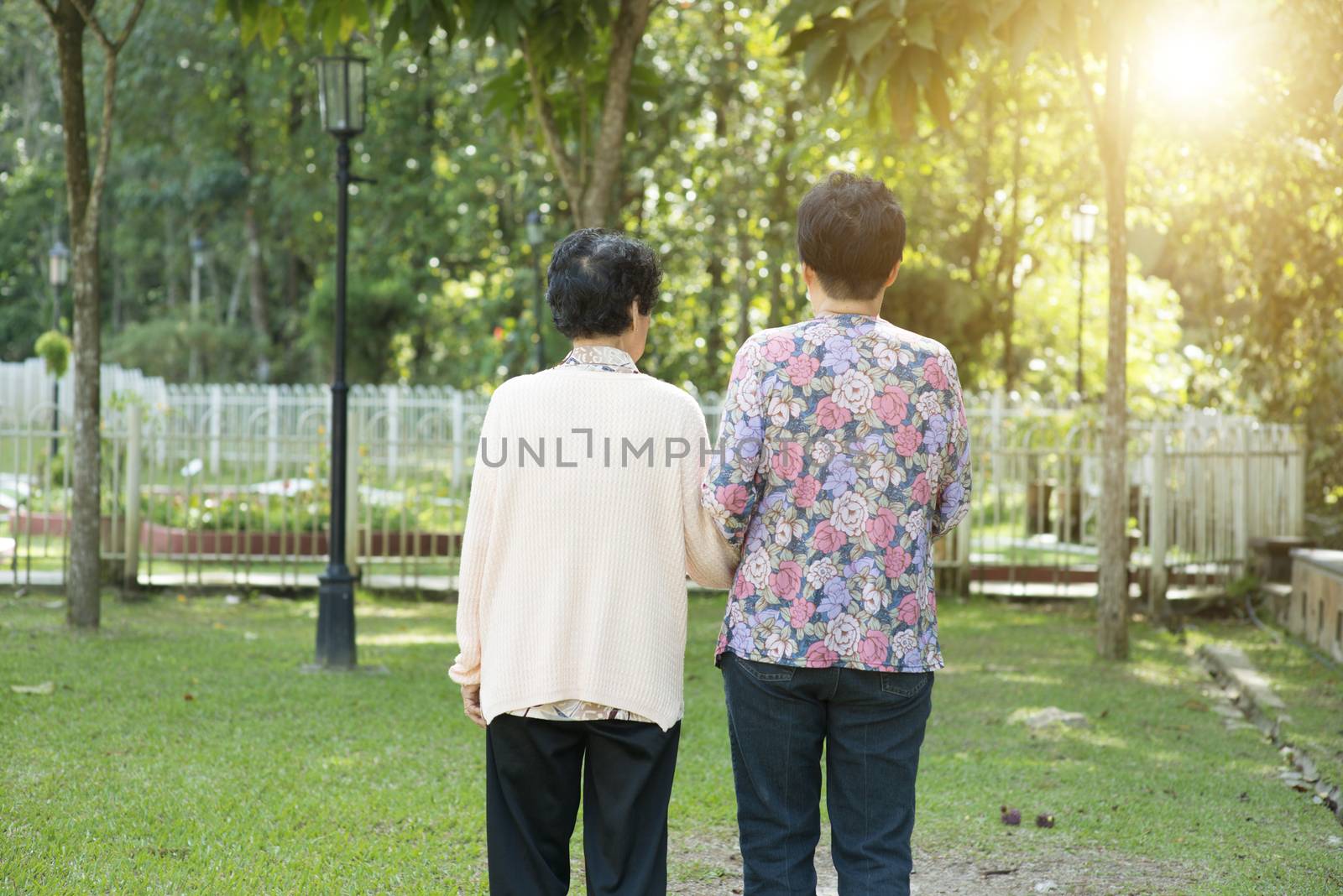 Rear view Asian elderly women walking in garden park by szefei