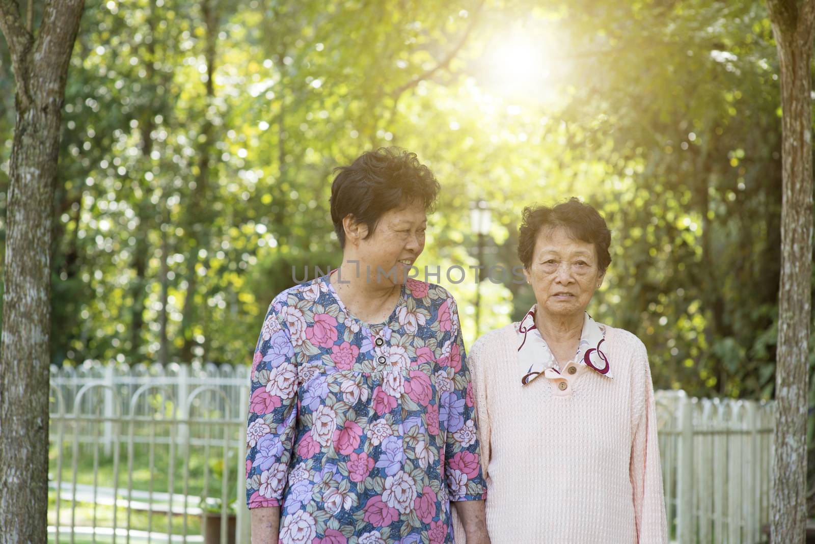 Candid shot of Asian old women walking at outdoor garden park in the morning.