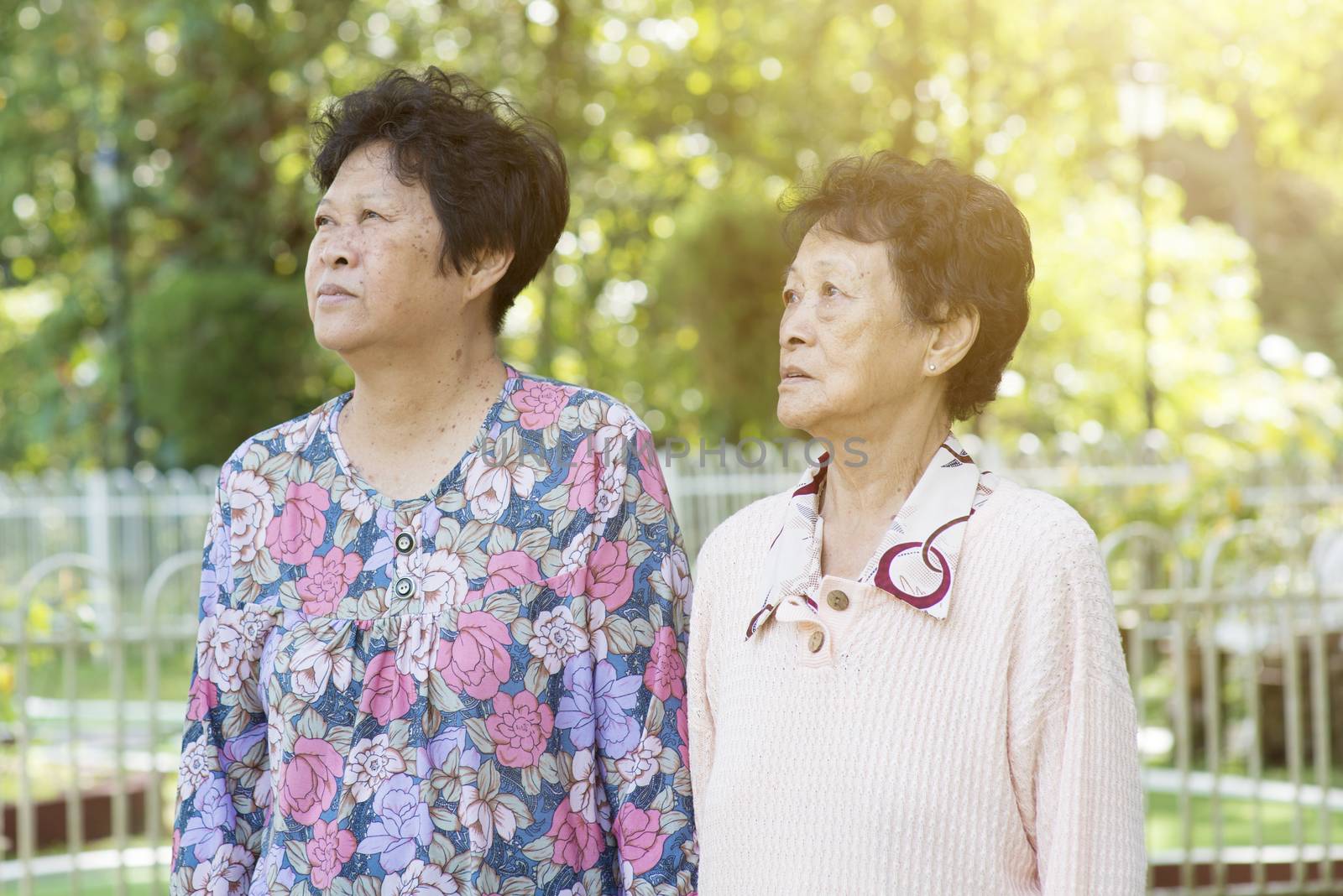Candid shot of Asian elderly women walking at outdoor garden park in the morning.