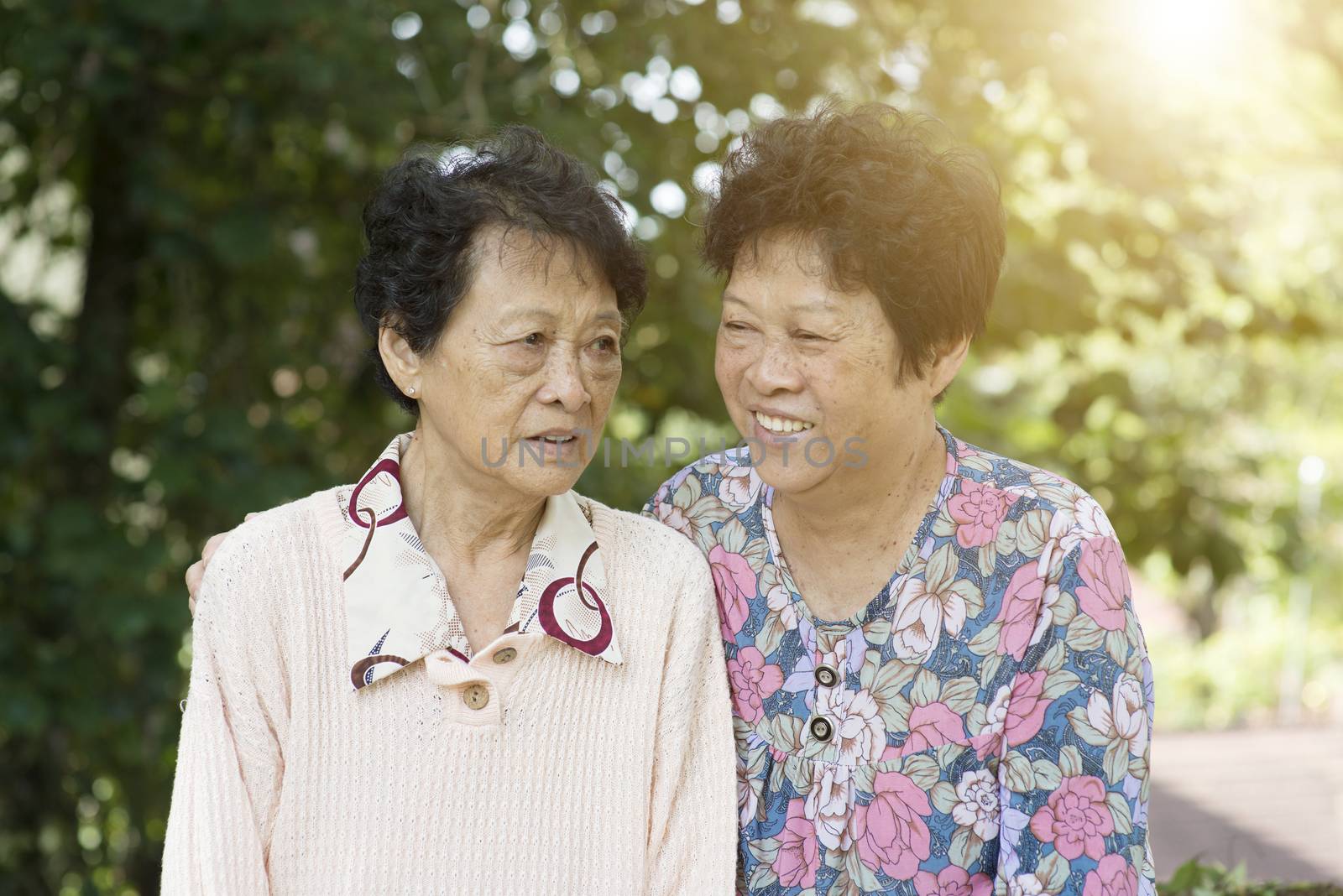 Candid shot of Asian elderly women talking at outdoor park in the morning.