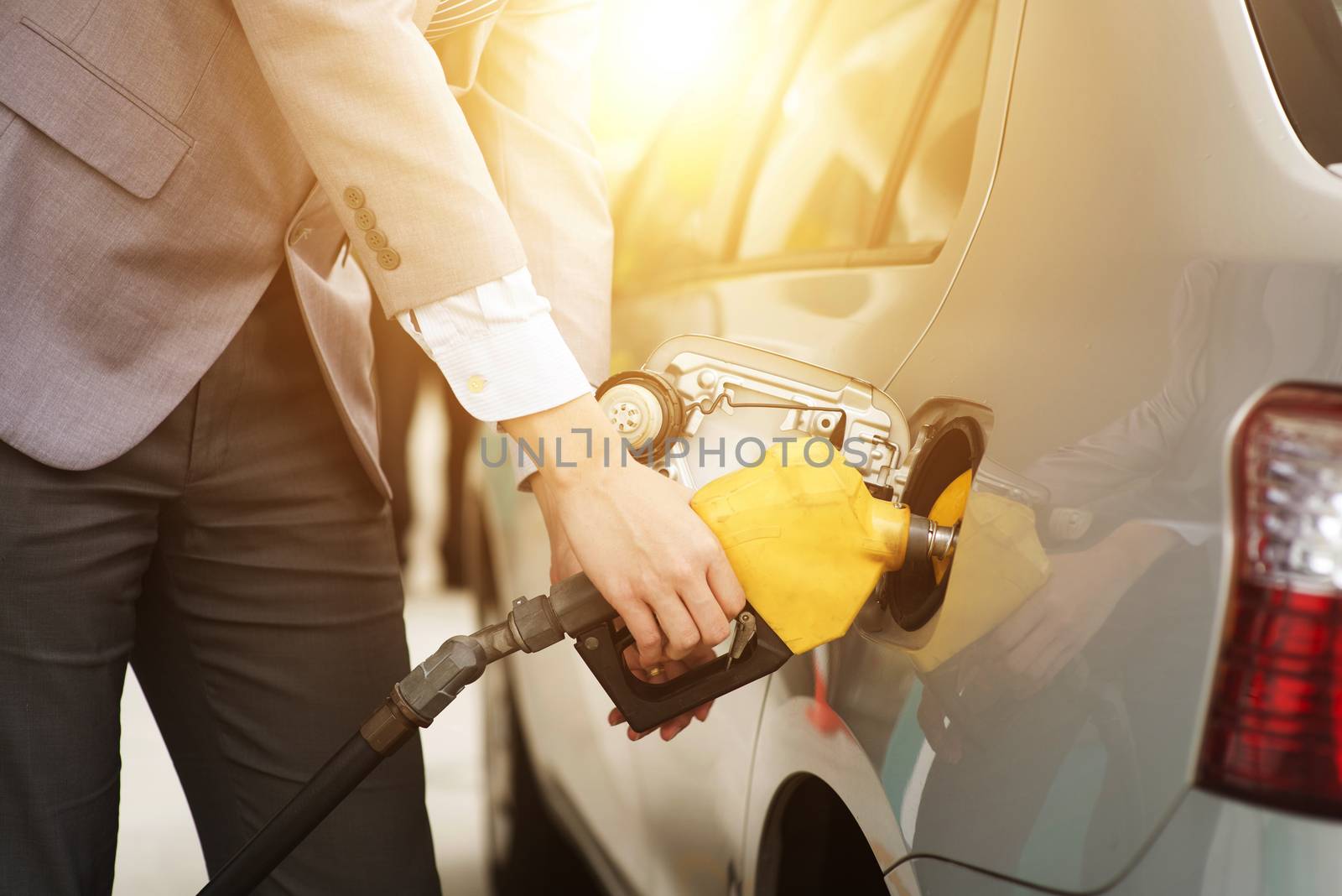 Refilling gas. Close up of man pumping gasoline fuel in car at petrol station.