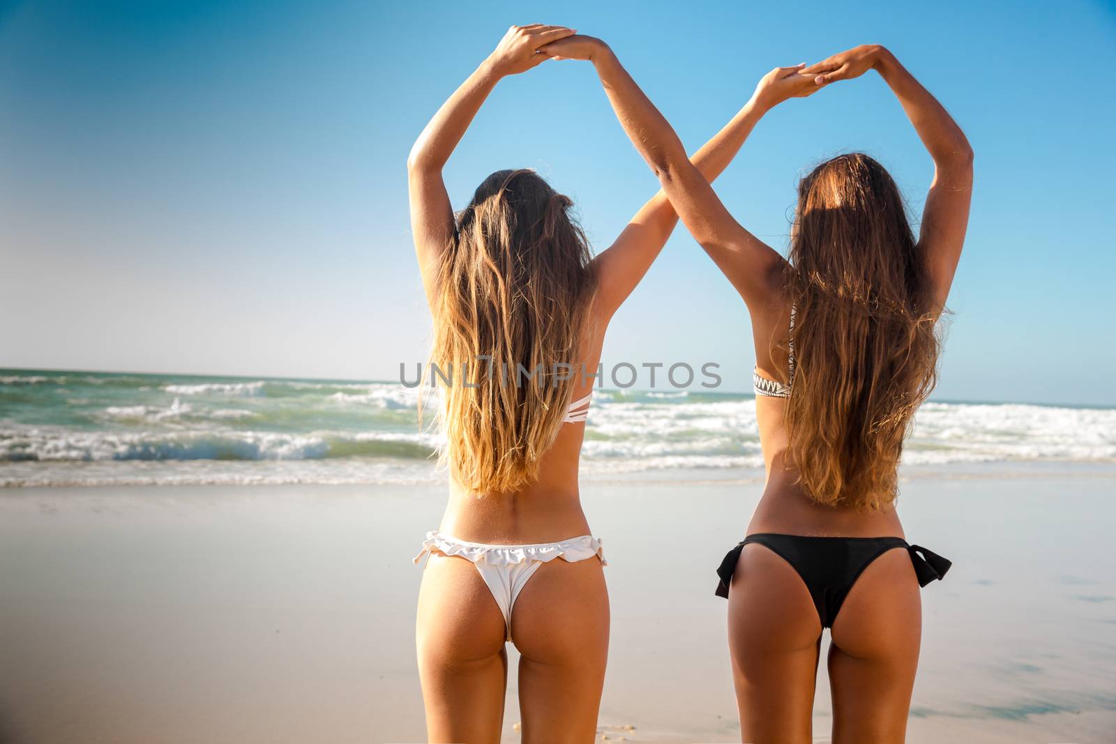 Beautiful girls in the beach giving her hands together