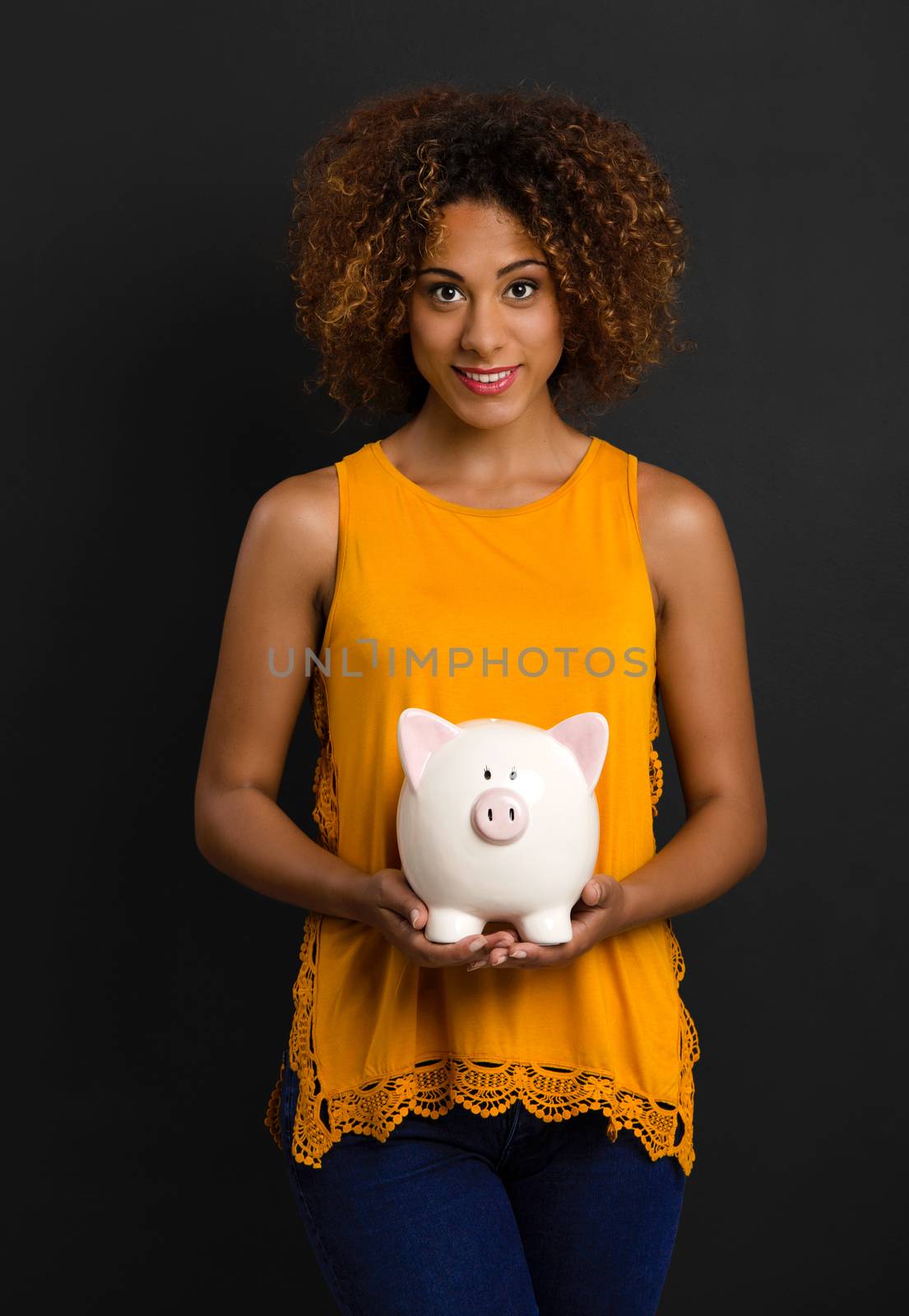 Portrait of a beautiful African American woman holding a Piggybank