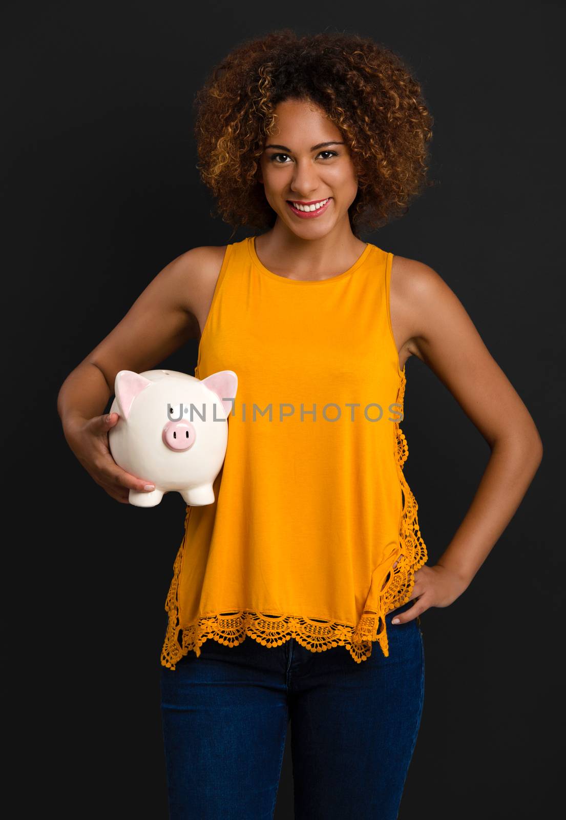 Portrait of a beautiful African American woman holding a Piggybank