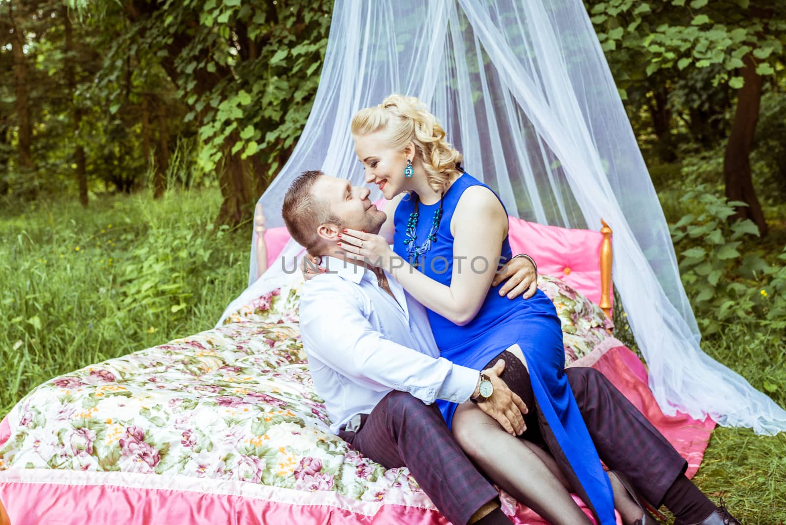 Man and woman sitting on the bed and looking at each other in the lawn in Lviv, Ukraine.