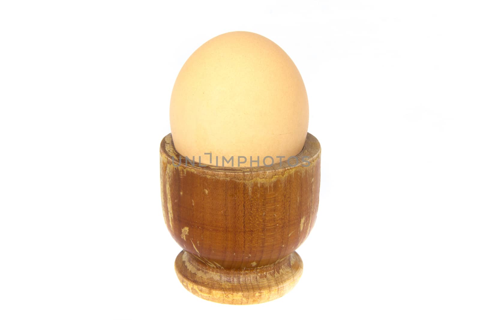 Boiled egg in wooden egg cup isolated on white by huntz