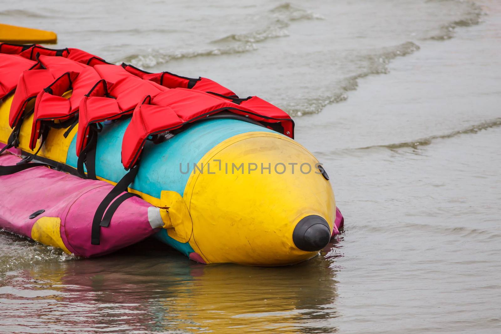 Banana boat lays on the beach by worrayuth