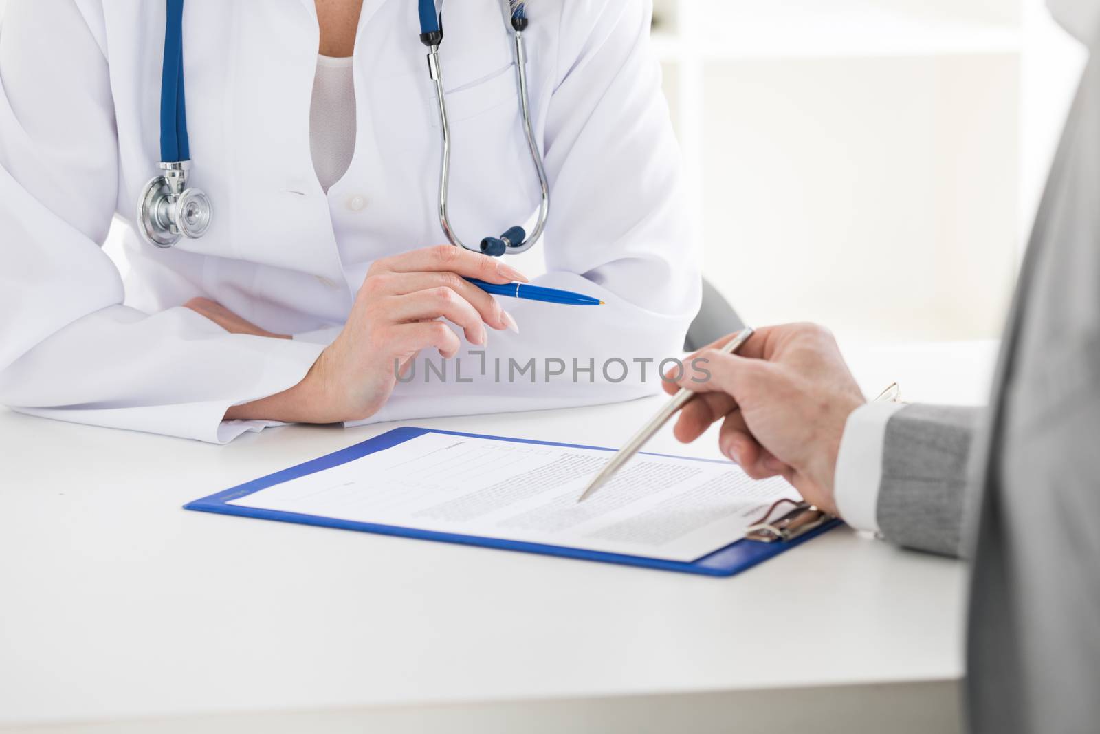 Female doctor holding consulting patient showing documents