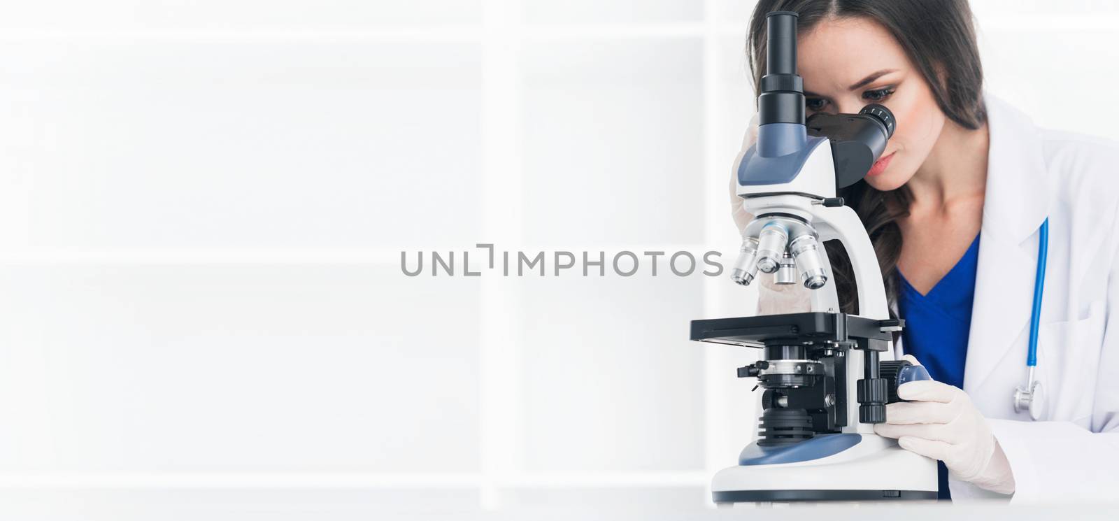 Female scientist working in a lab with microscope