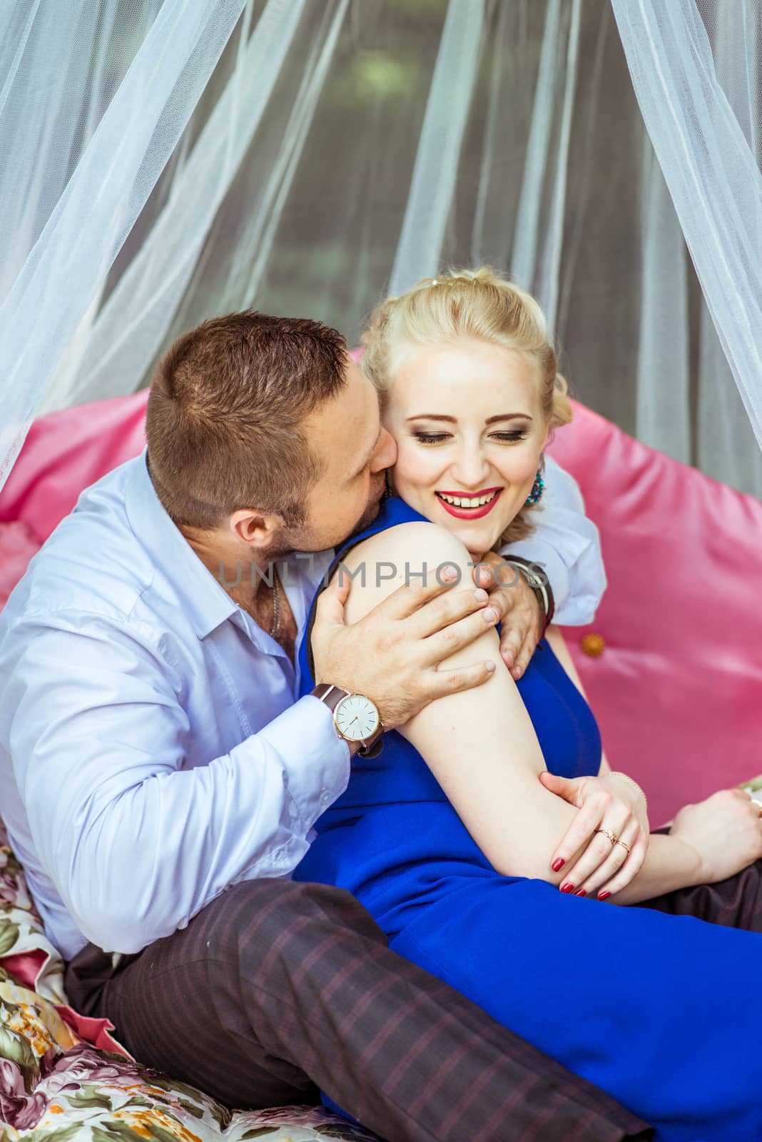 Man and woman sitting on the bed on the lawn and hugging in Lviv, Ukraine.