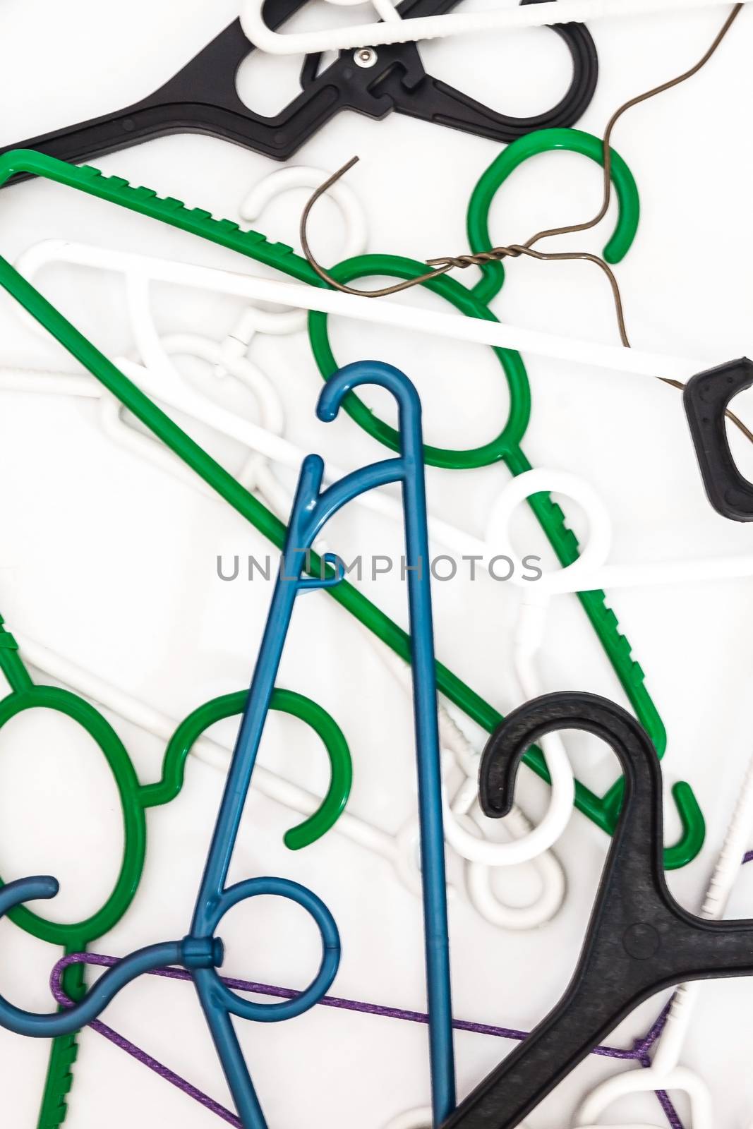 Many hangers of different shapes and colors, top view, white background.