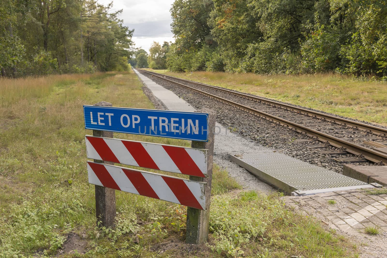 Unguarded, light rail railway crossing without barriers and warning lights in the East of the Netherlands
