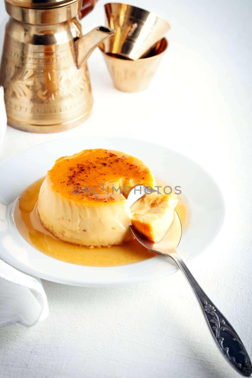 Creme caramel on a plate served on a table.