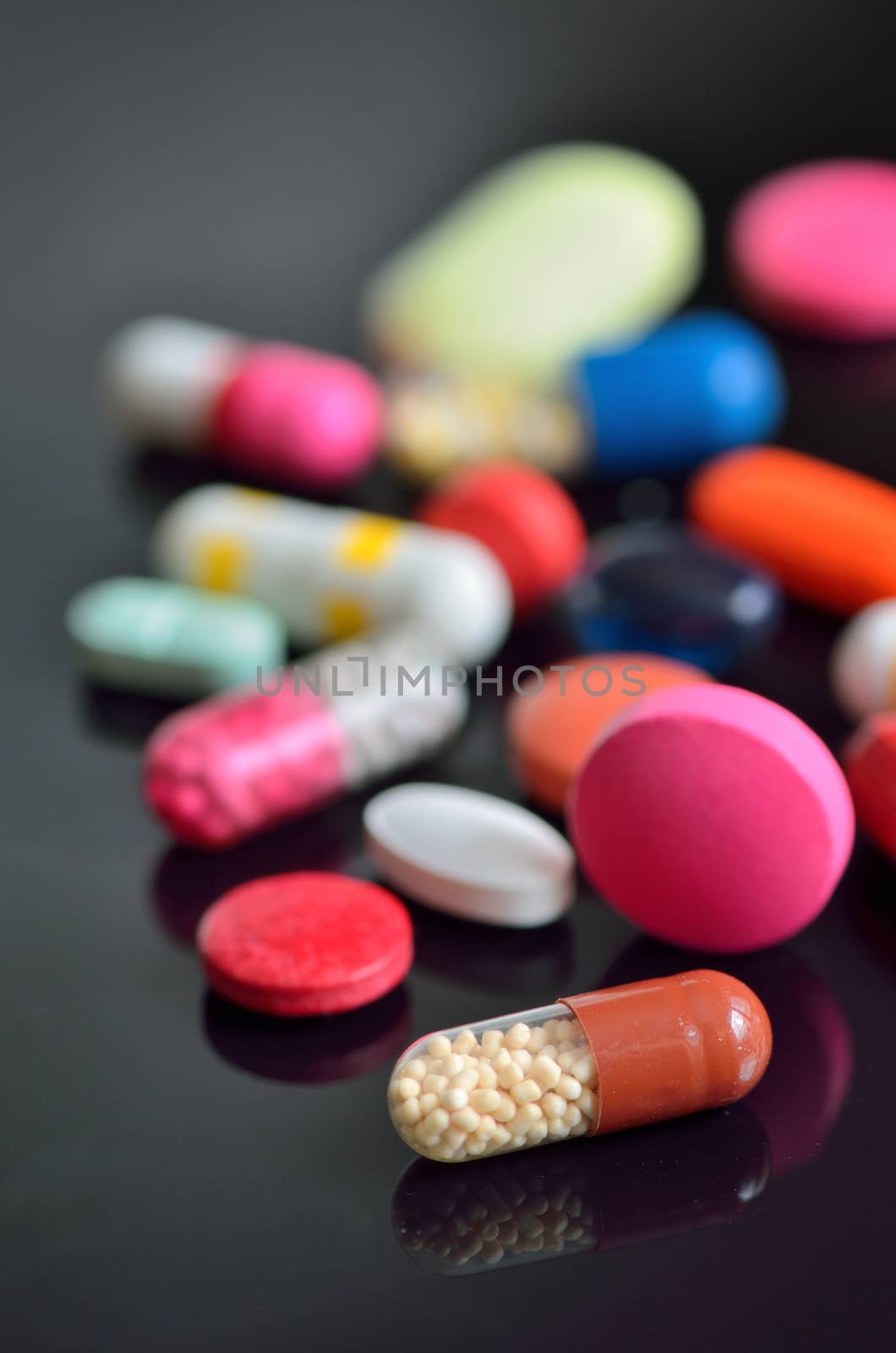 many different pills on black table