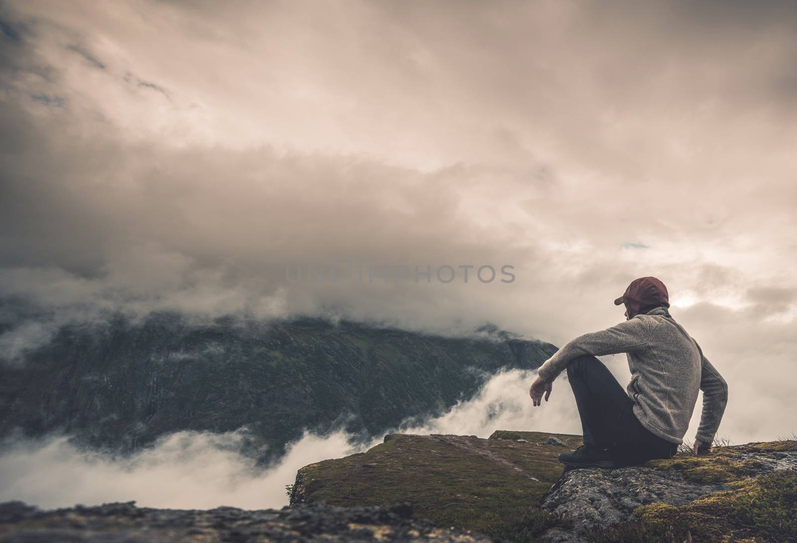 Resting with Scenic View. Hiker Resting on the Rock and Watching Scenic Cloudy Landscape.