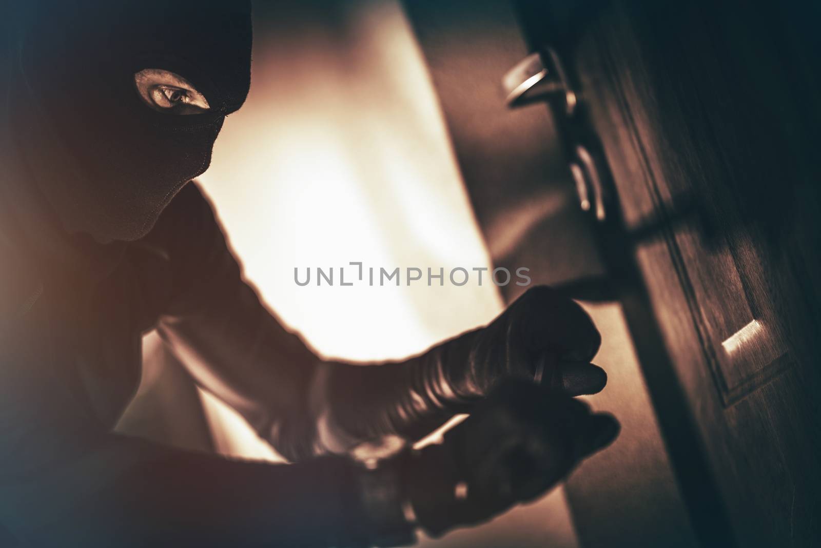 Caucasian House Burglar in Action. House Burglary Concept Photo. Home Safety Systems.