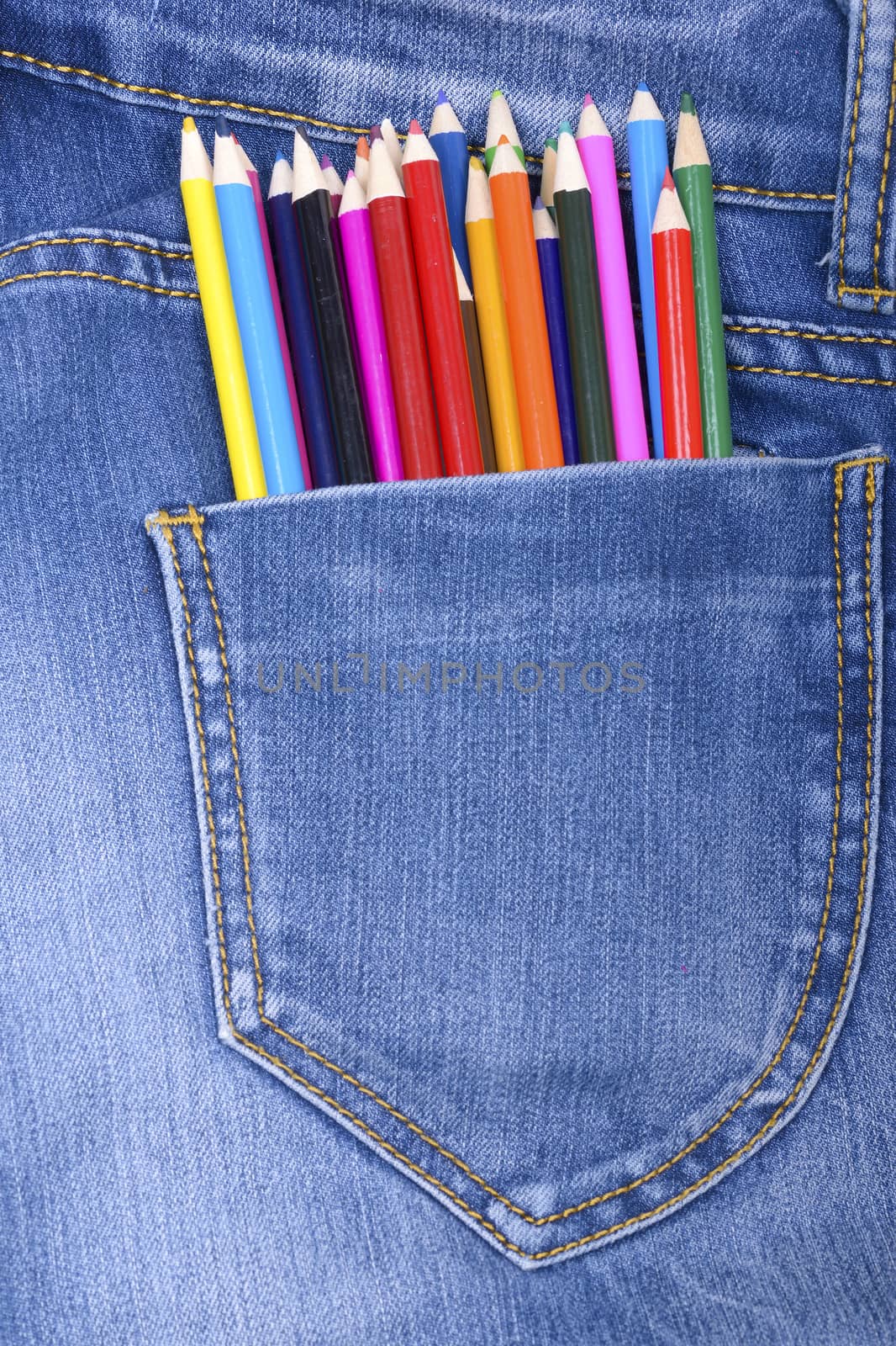 Pocket jeans and a group of colorful drawing pencils