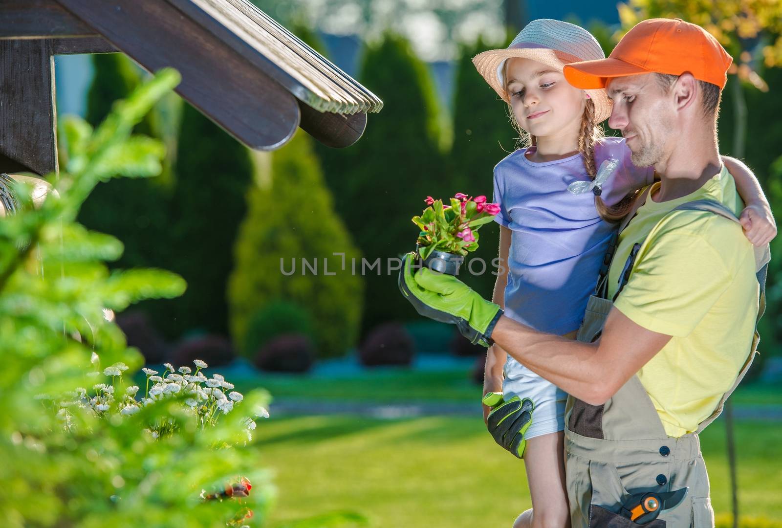 Father and Daughter in Garden. Father Explaining His Child How The Nature Works.