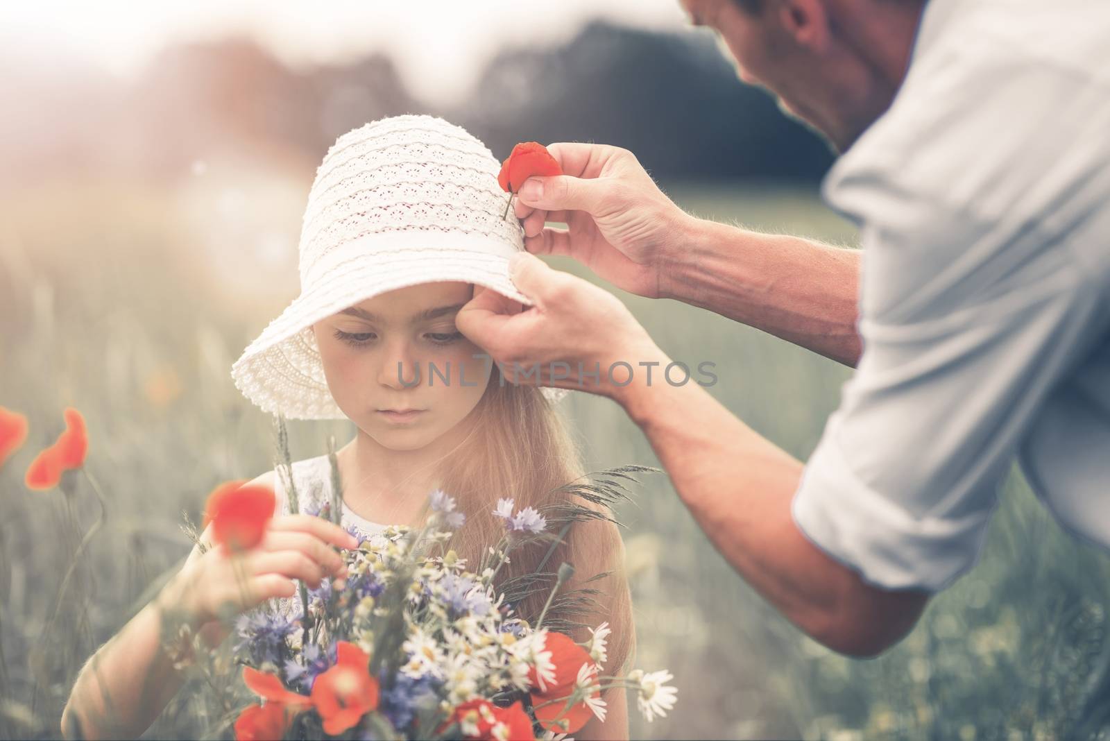 Father and His Daughter Having Fun on the Meadow Between Wildflowers Like Poppies. Caucasian Father and Daughter. 