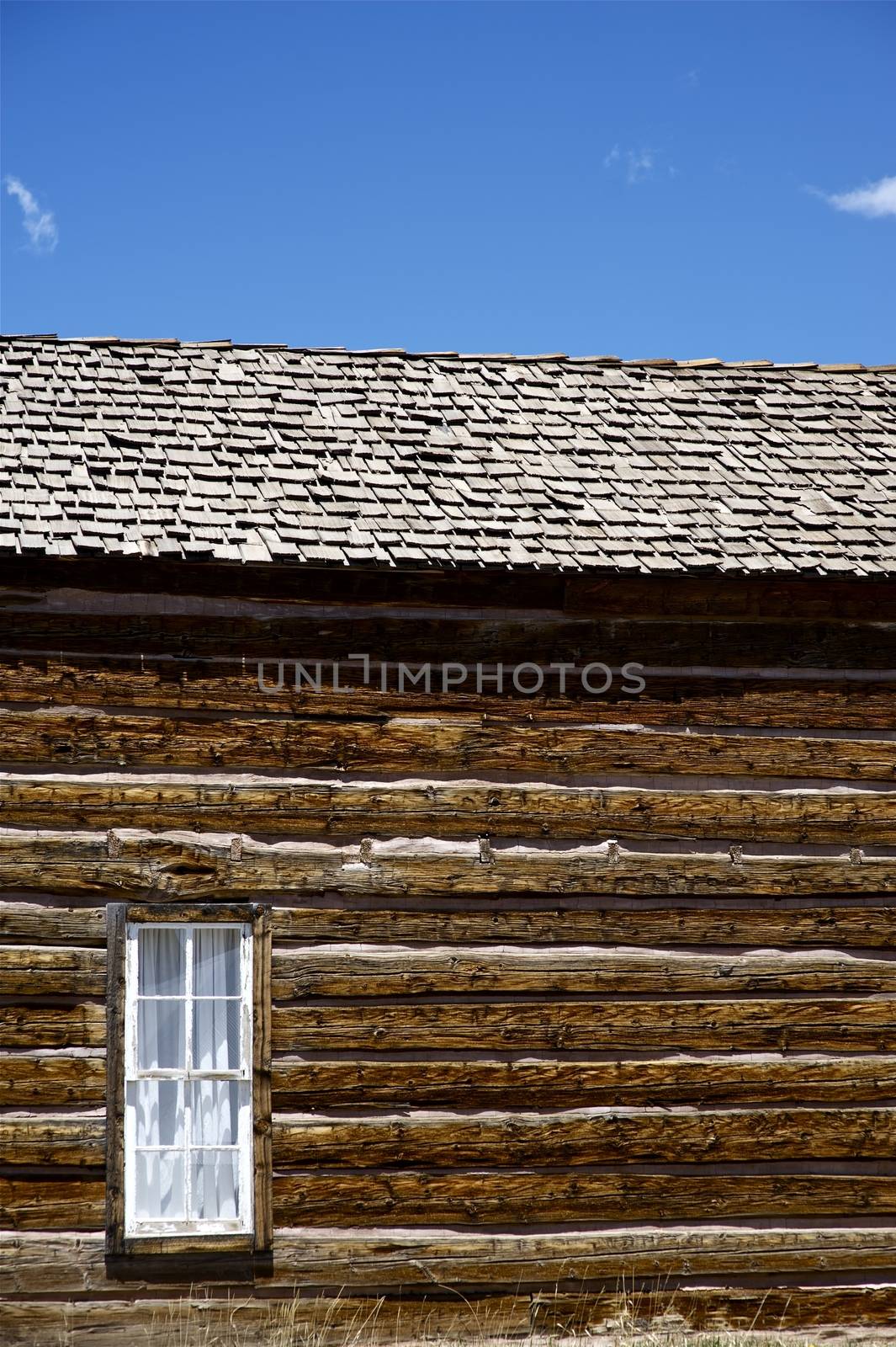 Vintage Building - Very Old Colorado Log House with Small Window. Vertical Photography. Colorado U.S.A.