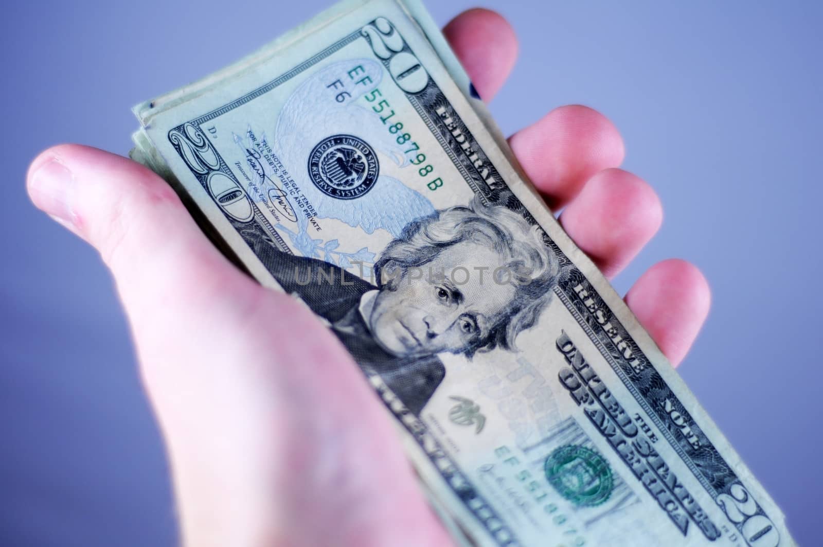Twenty US Dollars Bills in Hand. Light Blue Background