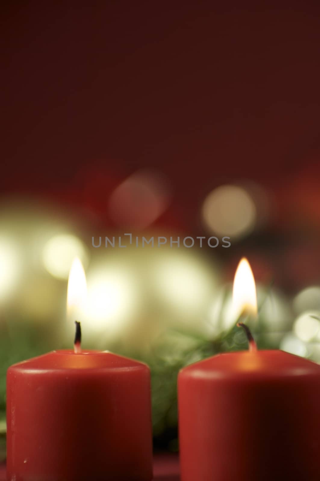 Two Red Candles with Bokeh. Christmas Ornaments in the Bokeh Background