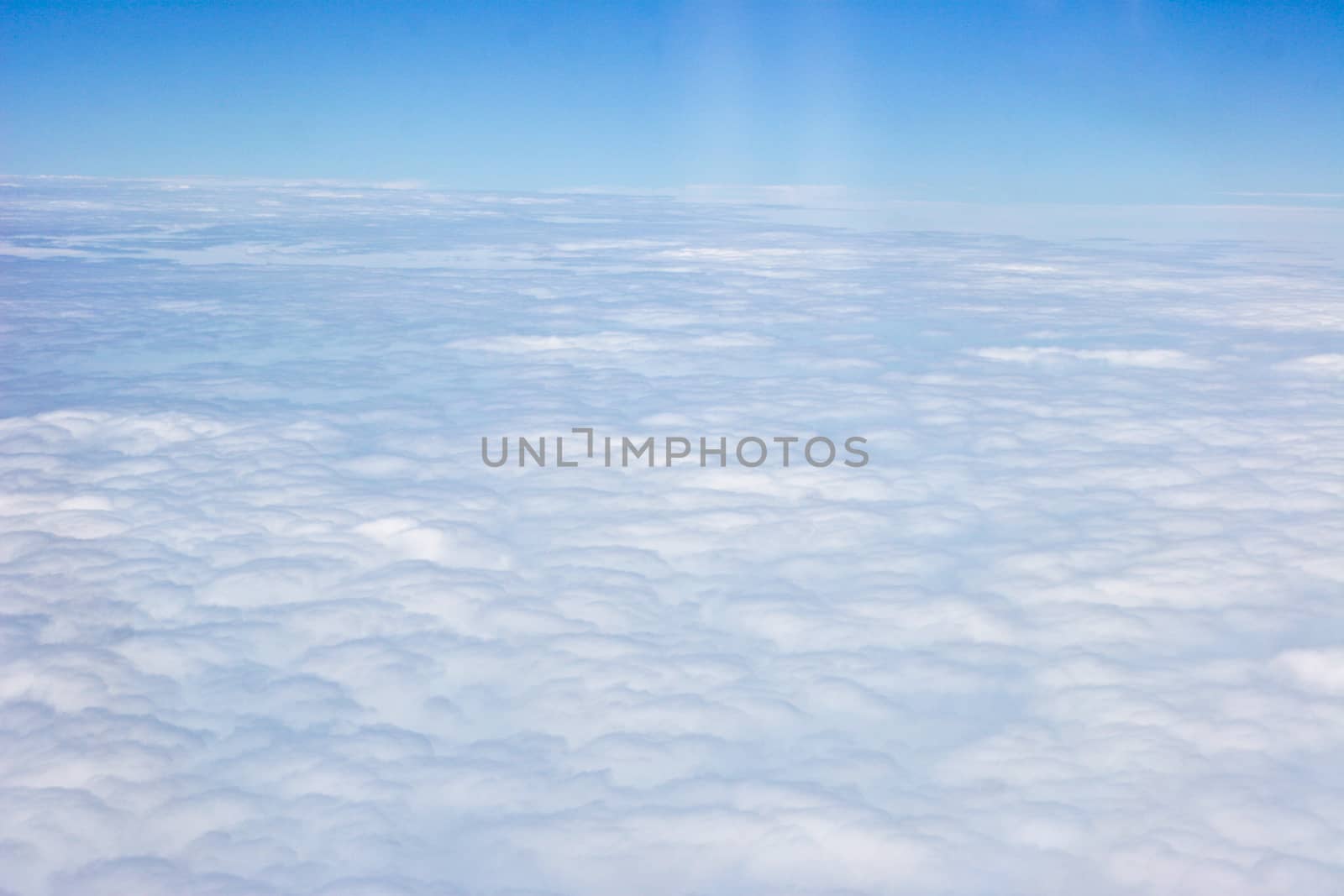 White clouds taken form above while flying in a plane.