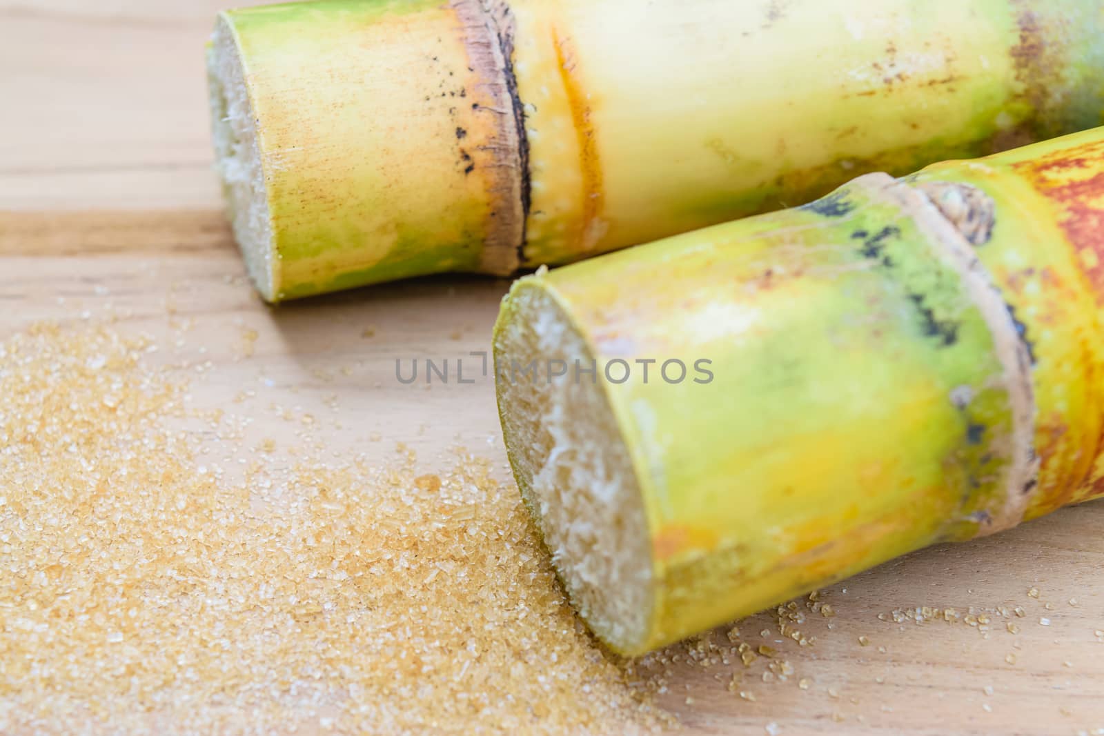 brown sugar and sugarcane on wooden table