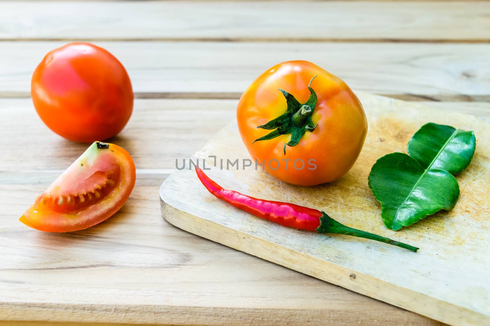 Tomatoes on chopping board with wooden