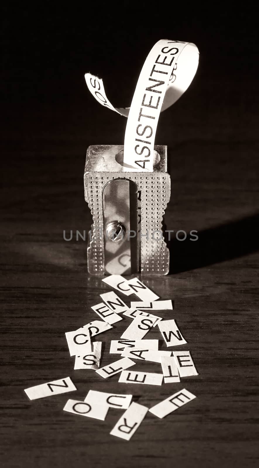 Metal sharpener cutting pieces of paper. Visual metaphor. Vertical image.