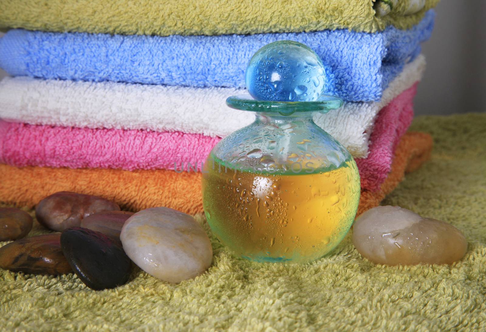 Blue bottle with massage oil on a background of towels