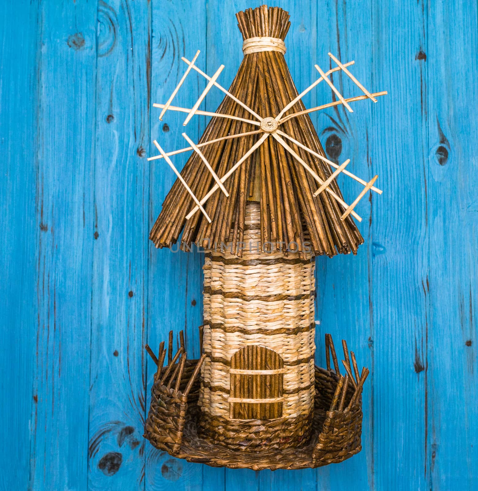 From above miniature decorative braided mill on blue wooden board in Ukraine
