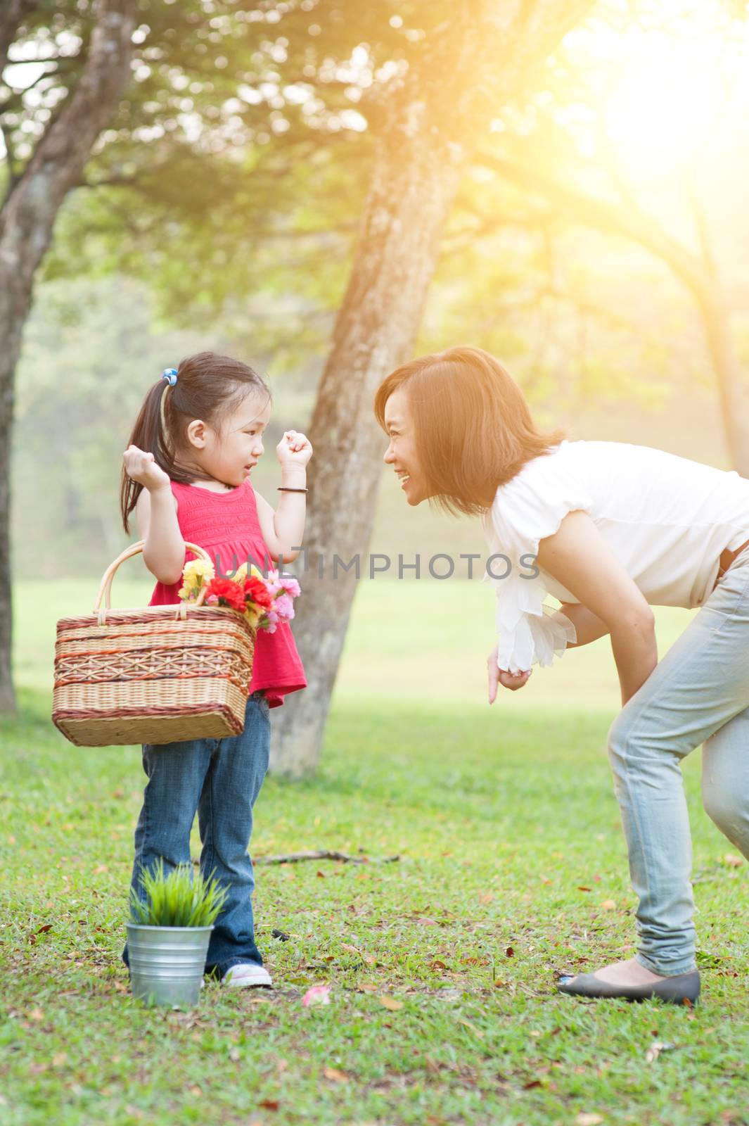 Lifestyle portrait mom and daughter in happiness at the outside in the meadow, family outdoor fun, morning with sun flare.