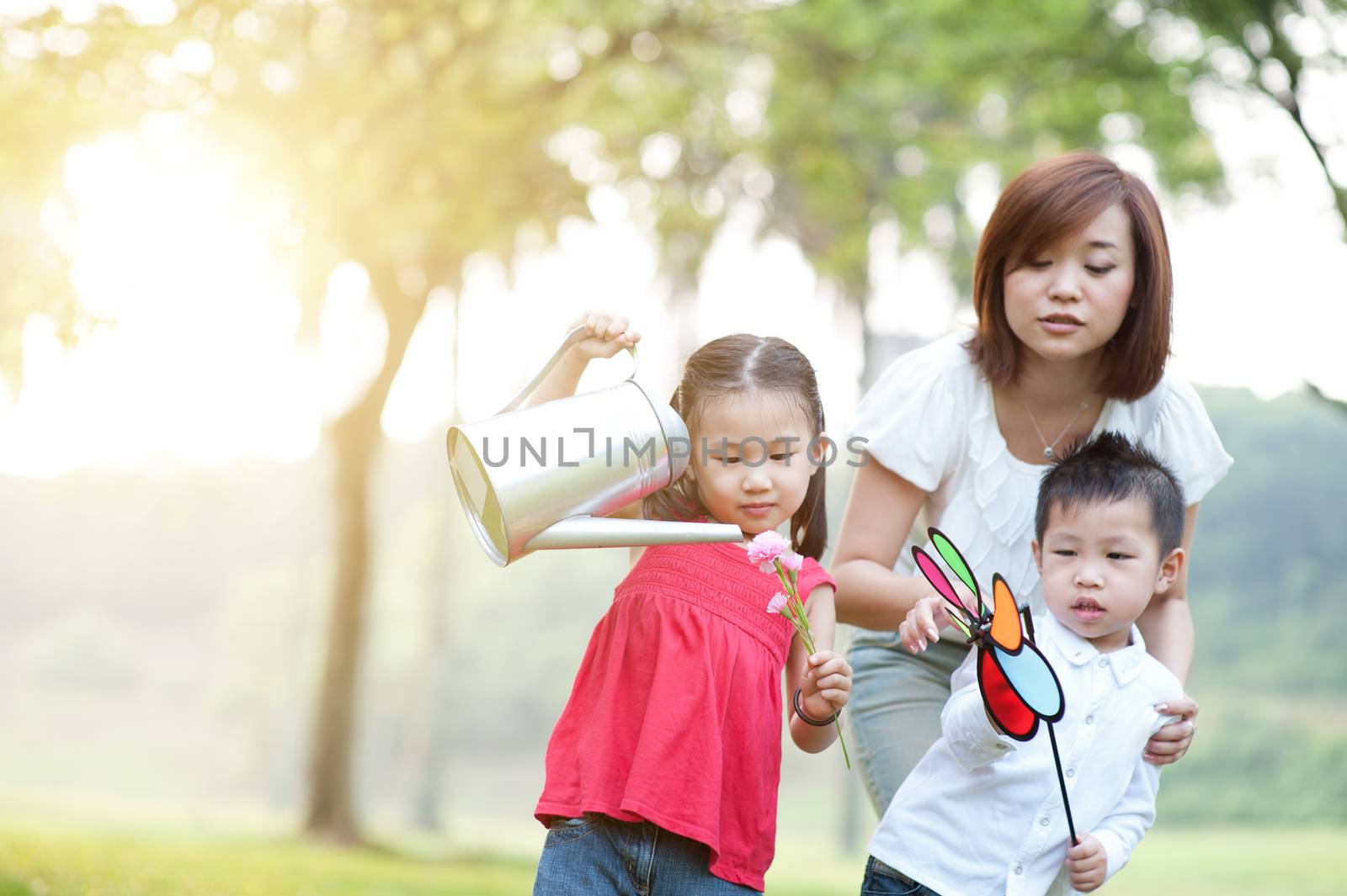 Asian mother and children playing at outdoor park. by szefei